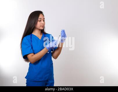 Eine junge Krankenschwester bereitet einen Schuss für ihre Patientin vor. Stockfoto