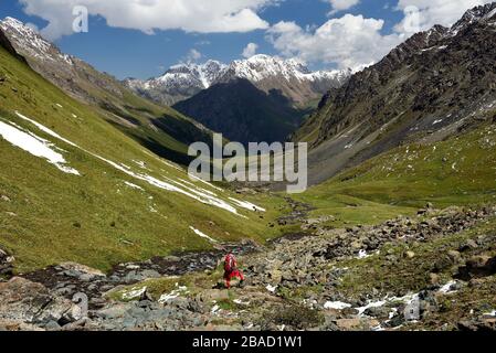Tourist auf der Route vom Pass Teleti 3800 m am Terskey Alatau Gebirge in den Tian Shan Bergen. Kirgisistan, Zentralasien.