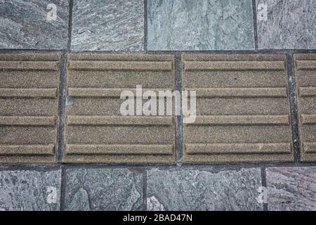 Gelber taktiler Pflaster für Sehbehinderte auf einem Bürgersteig in Nara, Japan Stockfoto