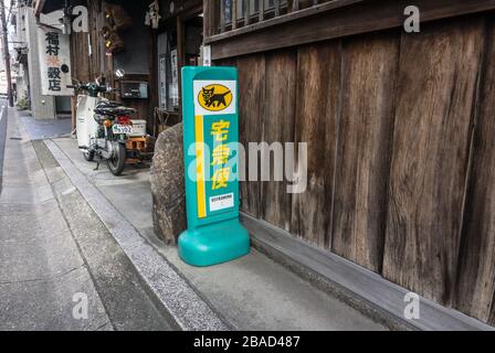 Ein Schild, das einen Sammelpunkt für Kuroneko Yamato Transport anzeigt Kurierdienst vor einem alten Holzhaus in Nara Japan Stockfoto