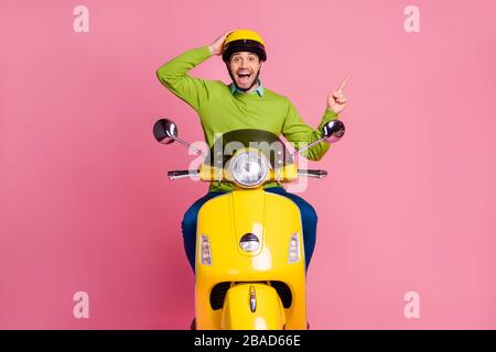 Porträt seines schönen, attraktiven und fröhlichen fröhlichen Wucherboutiquen mit dem Motorrad, der Werbung Ratschläge zeigt neue Entscheidung isoliert über rosafarbenem Pastell Stockfoto
