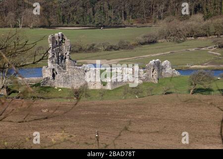 Die bekannte Burgruine Ogmore im Dorf Ogmore in der Nähe von Bridgend und neben dem Fluss Ogmore mit Trittsteinen zum gegenüberliegenden Ufer Stockfoto