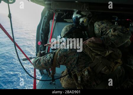 SÜDCHINESISCHE SEE (15. März 2020) EINE Marine mit Scout Sniper Platoon, Waffen-Gesellschaft, Battalion Landing Team, 1st Battalion, 5th Marines, 31st Marine Expeditionary Unit (MEU), feuert die Tür eines MH-60S Sea Hawk Hubschraubers aus, der den "Island Knights" der Helicopter Sea Combat Squadron (HSC) 25 zugewiesen ist, Mit einer halbautomatischen Sniper-Anlage M110 während einer Live-Feuer-Übung mit Luftsniper. Amerika, Flaggschiff der America Expeditionary Strike Group, 31. MEU-Team, arbeitet im 7. US-Flottengebiet, um die Interoperabilität mit Verbündeten und Partnern zu verbessern und als bereites Unternehmen zu dienen Stockfoto