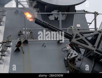 PAZIFISCHER OZEAN (13. März 2020) der Lenkflugkörperzerstörer der Arleigh-Burke-Klasse USS Rafael Peralta (DDG 115) feuert sein Phalanx-Nahkampfwaffensystem am 13. März 2020 an. Rafael Peralta, Teil der "Theodore Roosevelt Carrier Strike Group", befindet sich auf einem planmäßigen Einsatz im Indopazifik. (USA Navy-Foto von Mass Communication Specialist, 2. Klasse Jason Isaacs) Stockfoto