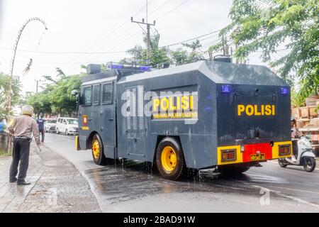 März 2020. Polizeimobilisierungseinheiten, die Desinfektionsmittel in Canggu, Bali, im Touristengebiet sprühen. Indonesien. Virenschutzprogramm der Regierung. Stockfoto