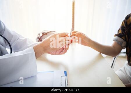 Der Arzt bittet und erklärt die Krankheit und gibt die Medikamente. Mit weiblichen Patienten in seinem Büro im Krankenhaus. Stockfoto