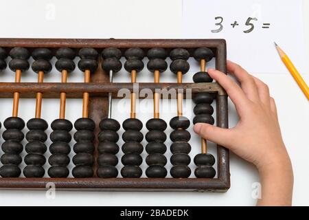 Kid, das Abacus verwendet, um einfache Additionalgleichung zu berechnen Stockfoto