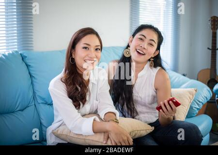 Lifestyle portrait Asiatische Frauen der besten Freunde - glücklich lächelnd auf dem Sofa im Wohnzimmer Stockfoto