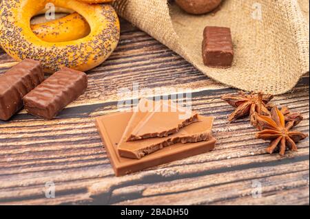 Bagels, Sternanis und Schokolade auf Holzgrund. Nahaufnahme Stockfoto