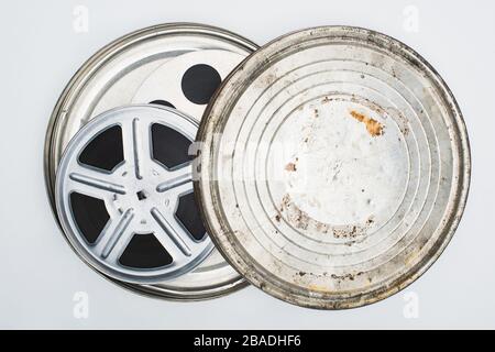 Draufsicht der Filmrollen mit Band in roster Blechkoffer auf weißem Hintergrund Stockfoto