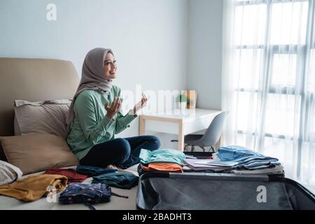 Muslimische Frauen danken Gott dafür, dass sie die Möglichkeit haben, Umrah zu besuchen, nachdem sie Kleidung vorbereitet haben, bevor sie gehen Stockfoto