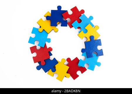 Bunte Puzzles runder Rahmen auf weißem Hintergrund, Autismus-Konzept der frühen Kindheit, Kopierraum, Textraum. Stockfoto