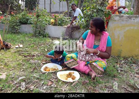 Eine Familie, die im Dorf Kumrokhali, Westbengalen, Indien zu Mittag essen kann Stockfoto