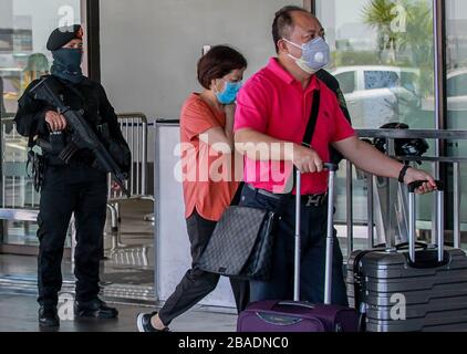 Pasay City. März 2020. Passagiere, die Gesichtsmasken tragen, kommen am 27. März 2020 für ihren Flug auf dem Ninoy Aquino International Airport (NAIA) in Pasay City auf den Philippinen an. Credit: Rouelle Umali/Xinhua/Alamy Live News Stockfoto