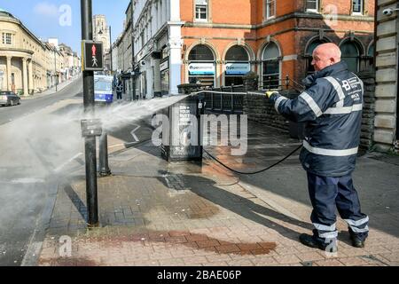 Arbeiter des Bristol City Centre Business Improvement District (BID) reinigen die öffentlichen Bereiche mit hohem Kontakt rund um Park Street und College Green, Bristol mit heißem Wasser mit Desinfektionsmittel und einem Hochdruckschlauch, da Großbritannien weiterhin in Sperrungen ist, um die Ausbreitung des Coronavirus einzudämmen. Die Reinigungsopertaion konzentriert sich auf Oberflächen, die einen hohen Kontakt mit der Öffentlichkeit haben. Stockfoto