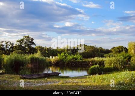 Schöne Landschaft mit einem Feld, Bäumen und einem Teich am Ecomuseum des Elsaß, dem Freilichtmuseum / Ungersheim. L'éco musée d'Alsace Stockfoto