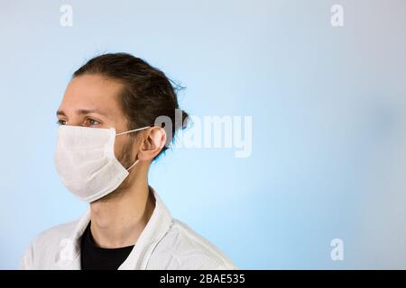 Ein Erwachsener, der in einem weißen Labormantel mit einer schützenden Gesichtsmaske bekleidet ist. Bereit für die Arbeit in einem Reinraum oder Labor Stockfoto