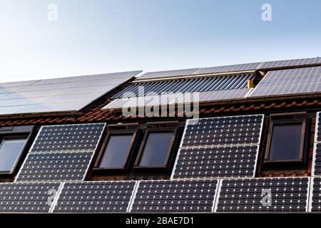 Haus mit Solarpaneelen und Solarpaneelen zur Wassererwärmung auf dem Dach. Stockfoto