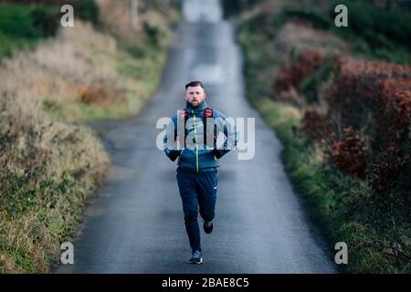 Mann, der auf der Straße läuft, Glasgow, Schottland. Stockfoto