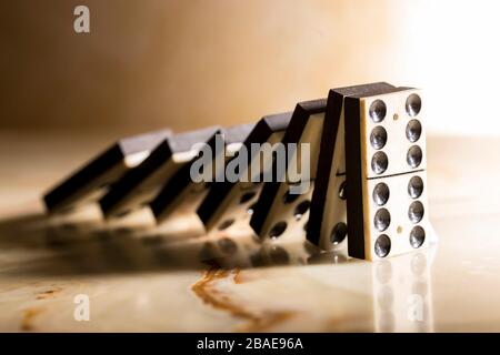 Domino als abstraktes Konzept. Wunderschönes, antiker Dominostein auf Schachbrett aus Marmor. Stockfoto