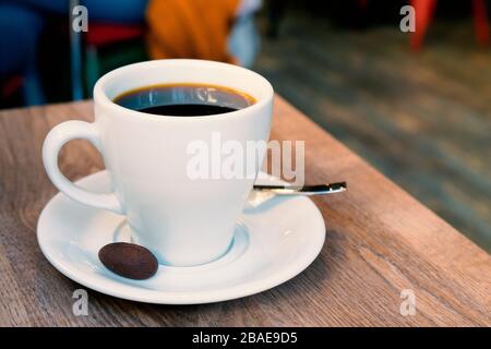 tasse Kaffee mit kleinem Plätzchen in der Cafeteria Stockfoto