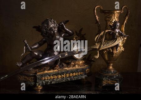 Französischer Offizierssäbel (Säbel) mit Manteluhr und Vase mit einem Engel.19. Frankreich. Stockfoto