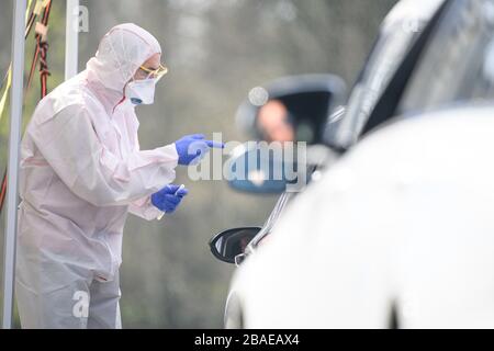 27. März 2020, Baden-Württemberg, Nürnberg: Ein Mitarbeiter spricht mit einem Autofahrer in einem Corona-Schmierzentrum, bevor er auf das Corona-Virus Sars-Cov-2 testet. Foto: Sebastian Gollnow / dpa Stockfoto