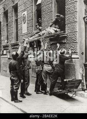 Österreichischen Bürgerkrieg. Polizeibeamte und Angehörige der Heimwehr bei der Erstürmung des Wiener Funkgebäudes. Soldaten tragen den Körper des m aus Stockfoto