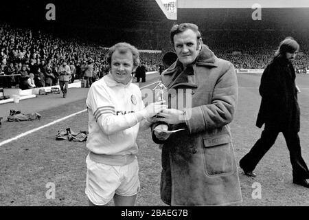 Leeds United-Manager Don Revie (r) überreicht Kapitän Billy Bremner (l) eine Trophäe Stockfoto