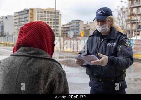 Saloniki, Griechenland - 23. März 2020: Ein Polizeibeamter überprüft die Dokumente eines Bürgers, da das Land die Verbreitung des COVID nicht unter Kontrolle hat Stockfoto