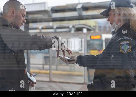 Saloniki, Griechenland - 23. März 2020: Ein Polizeibeamter überprüft die Dokumente eines Bürgers, da das Land die Verbreitung des COVID nicht unter Kontrolle hat Stockfoto
