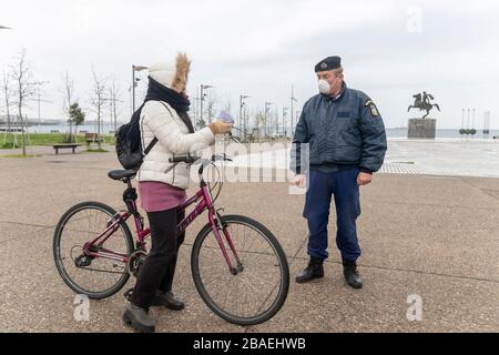 Saloniki, Griechenland - 23. März 2020: Ein Polizeibeamter überprüft die Dokumente eines Bürgers, da das Land die Verbreitung des COVID nicht unter Kontrolle hat Stockfoto