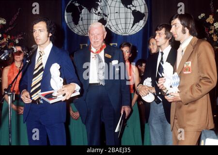 Westdeutschland-Kapitän Franz Beckenbauer (l) hält nach den Vorträgen beim Siegesbankett im Hilton Hotel in München eine Rede, die von FIFA-Präsident Sir Stanley Rous (zweites l), Hollands Johan Cruyff (zweites r) und Polens Kazimierz Deyna (r) verfolgt wird. Stockfoto