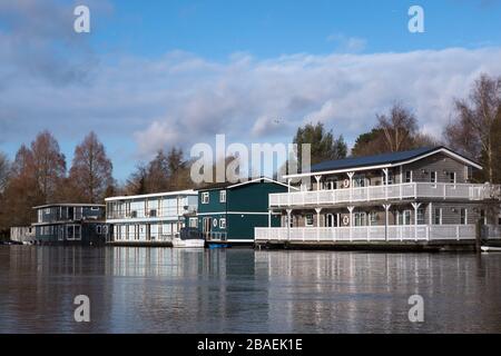 Schwimmende Hausboote moorierten am Ufer der Themse nahe Molesey und Hampton Court im Vereinigten Königreich Stockfoto