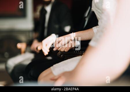 Hochzeitspaare halten sich an der Cerenomie und sitzen im Registrierungsbüro Stockfoto