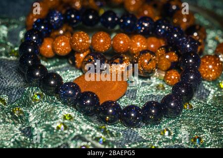 Boho besteierte Armbänder mit braunen und dunkelblauen Glitter-Glassteinen. Stockfoto