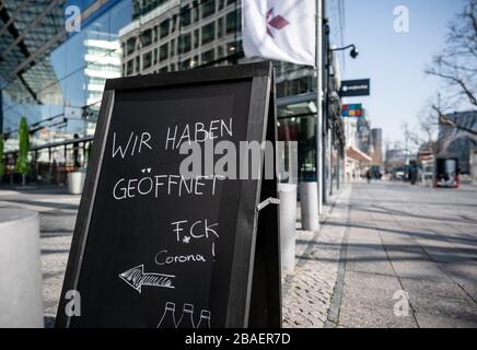 Berlin, Deutschland. März 2020. Am Kranzler-Eck am Kurfürstendamm hat trotz der Corona-Krise ein Café eröffnet und mit einem Schild "wir sind offen F * ck Corona" versehen. Credit: Michael Kappeler / dpa / Alamy Live News Stockfoto