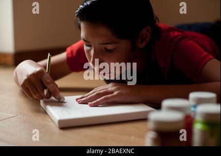 Der junge Junge macht gerne zu Hause Kunsthandwerk Stockfoto