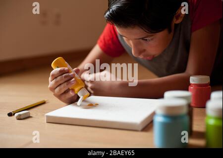 Der junge Junge macht gerne zu Hause Kunsthandwerk Stockfoto