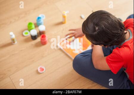 Der junge Junge macht gerne zu Hause Kunsthandwerk Stockfoto