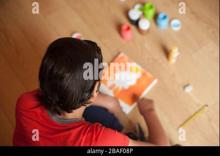 Der junge Junge macht gerne zu Hause Kunsthandwerk Stockfoto