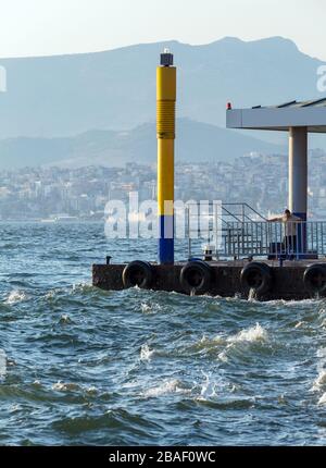 Alsancak, Izmir/Türkei 07/28/2015: Blick vom Pasaport Pier. Der Offizier wartet darauf, dass die Fähre anfährt. Stockfoto