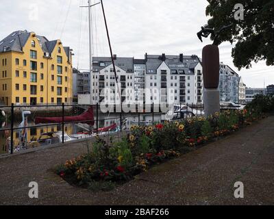 ALESUND, NORWEGEN, am JULI 2019: Yachts, Blumen und Gebäude der europäischen Stadt in der Region Romsdal mit bewölktem Himmel im warmen Sommertag am Morgen. Stockfoto