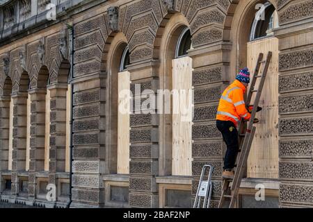 Arbeiter steigen in die Fenster eines Restaurants in Bath, Somerset, nachdem die britische Regierung strikte Einschränkungen angekündigt hatte, um Coronavirus zu versuchen und einzudämmen. Stockfoto