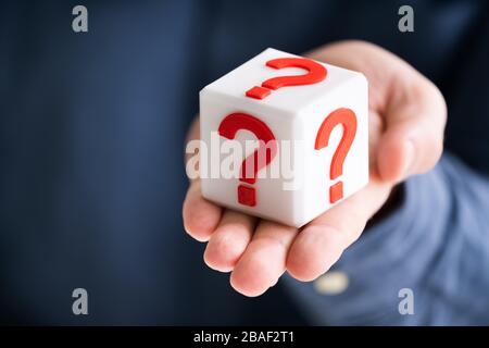 In der Nähe der Person Hand mit weißen Fragezeichen auf rote Block Stockfoto