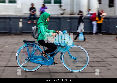 Eine junge Indonesierin, die auf dem Taman-Fatahillah-Platz, Jakarta, Indonesien radeln kann. Stockfoto