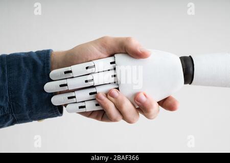 Nahaufnahme der Unternehmer die Hände schütteln mit Roboter Stockfoto
