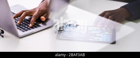 In der Nähe von einem Geschäftsmann Hand Analyse von Graphen auf Digital Laptop am Arbeitsplatz Stockfoto
