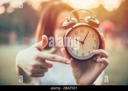 Die Close-Up-Hand zeigt zu Uhrzeiten, damit es Zeit ist, ein dringendes oder ein Kündigungskonzept zu machen.