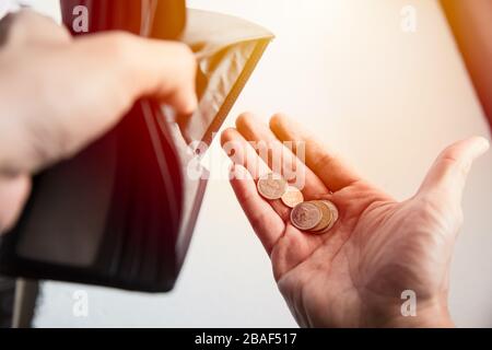 Die Menschen stehen vor einem wirtschaftlichen Abschwung. Kein Geld in der Brieftasche nur noch Münzen als armer zerbrochene Mann. Stockfoto